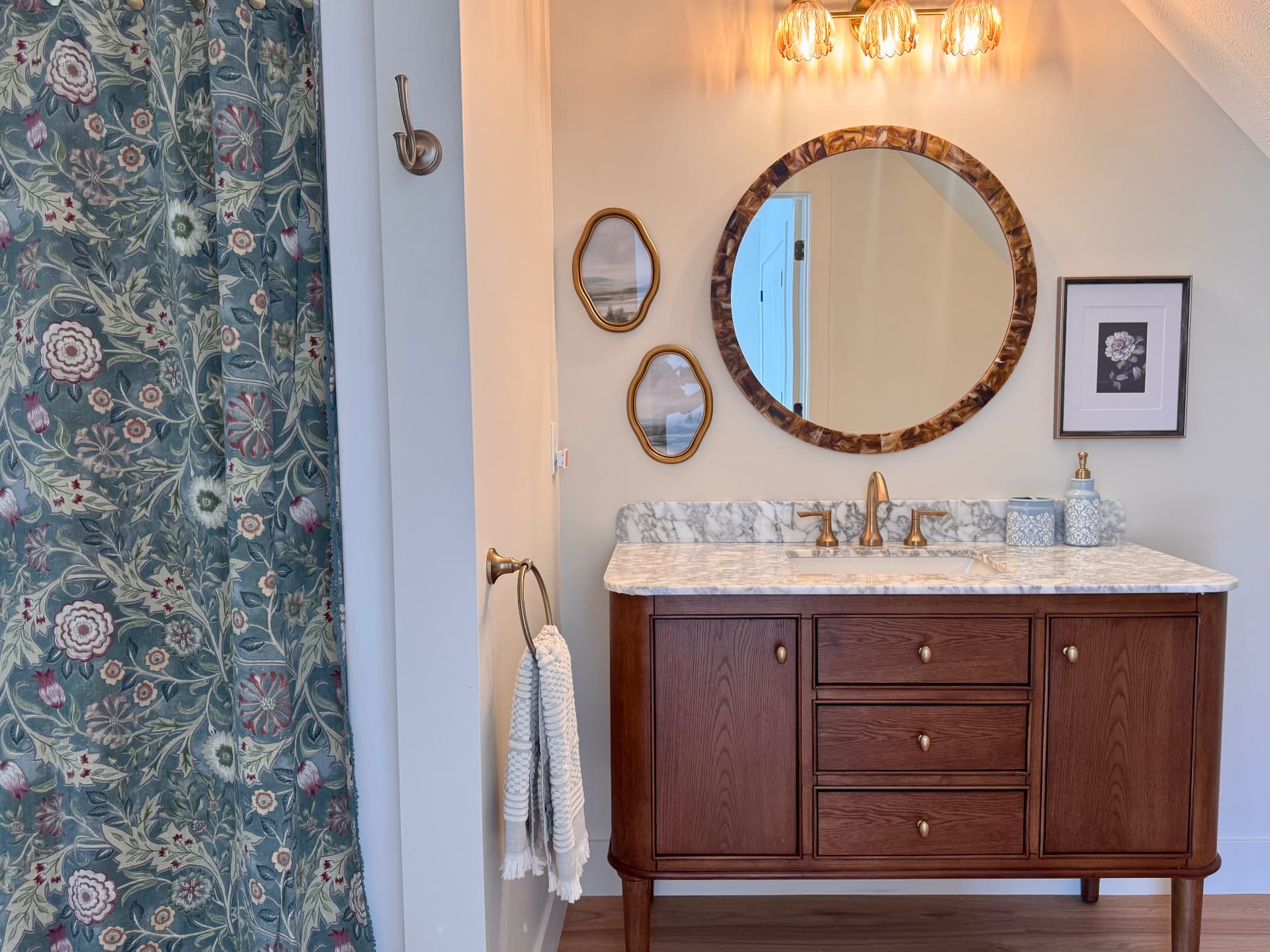The bathroom vanity with marble counter and floral shower curtain