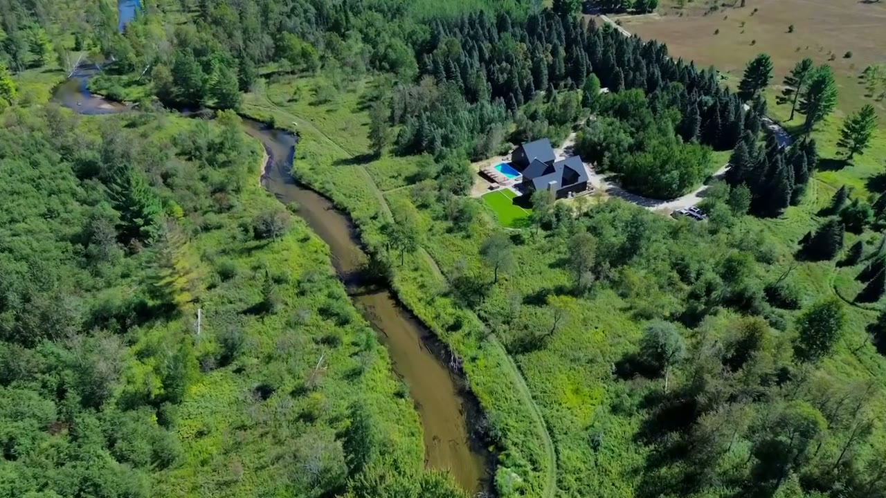 Aerial view of Ottaway Landing — the house, pool, and curving river among meadow and woods